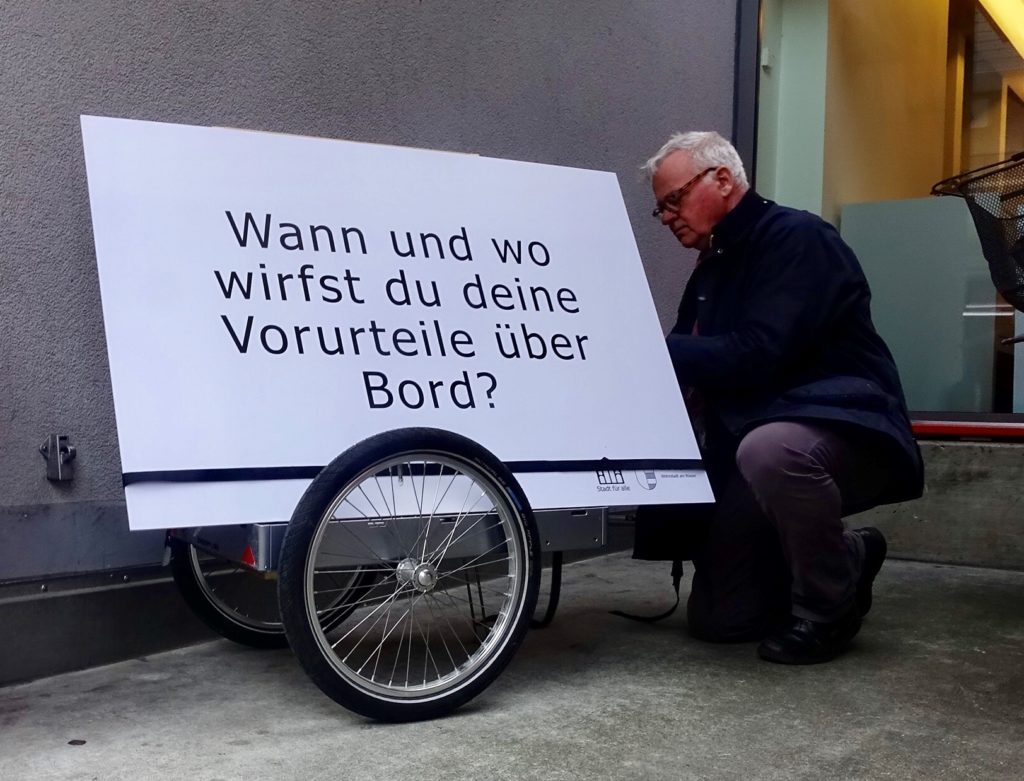 Peter befestigt die grosse Fragetafel auf seinem Veolanhänger.