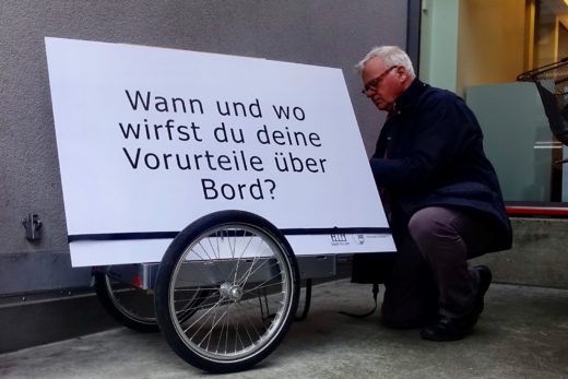 Peter befestigt die grosse Fragetafel auf seinem Veolanhänger.