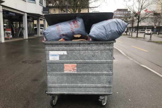Ein Abfallkontainer ist total überfüllt. Der Deckel schliesst nicht mehr richtig