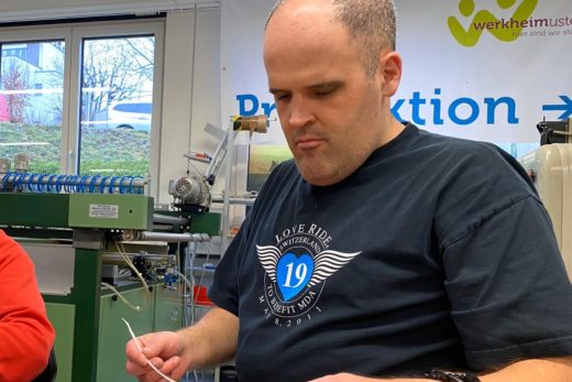 Ein Mann kontrolliert ein ausgedrucktes Schild. Der Mann arbeitet in der Arbeitsstätte vom Werkheim Uster