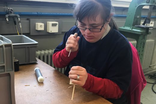 Junge Frau im Produktwerk vom Werkheim. Sie produziert K-Lumets, Anzündhilfen