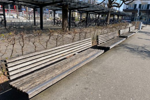 Leere Sitzbänke vor dem Bahnhof