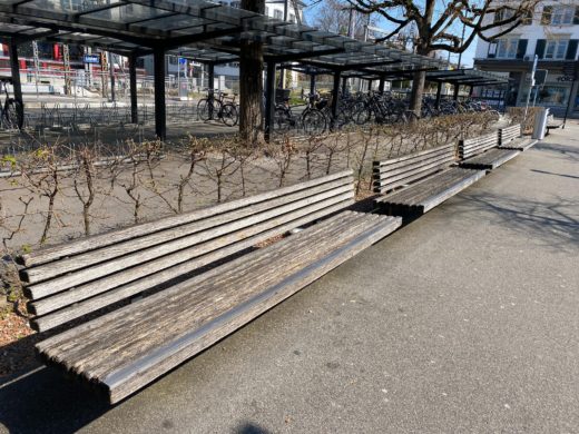 Leere Sitzbänke vor dem Bahnhof
