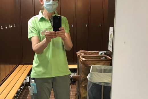 Eine Pflegrin mit Schautzmaske fotografiert sich selber in der Umkleide