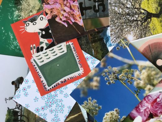 VIele unterschiedliche Postkarten auf einem Tisch ausgebreitet