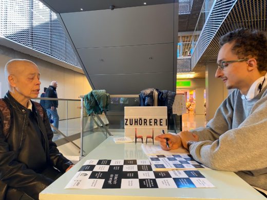 Eine Frau und ein Mann am Tisch der Zuhörerei im Einkaufszentrum Illuster