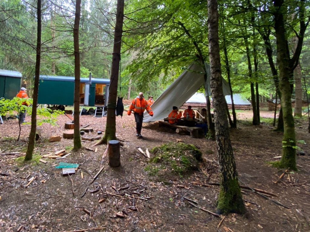 Arbeitsplatz vom Werkheim im Wald. Männer bei der Arbeit