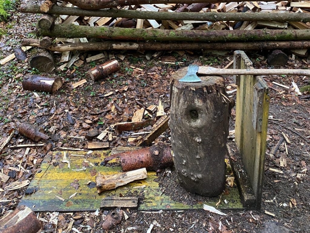 Ein beil ruht auf einem Holzpflock