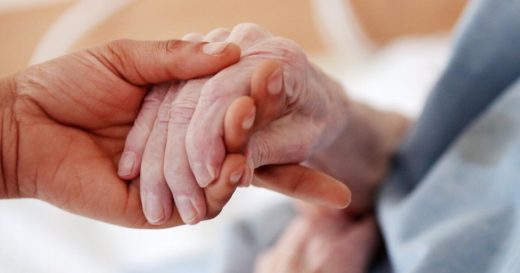 Eine alte Hand wird zärtlich von einer jungen Hand gehalten