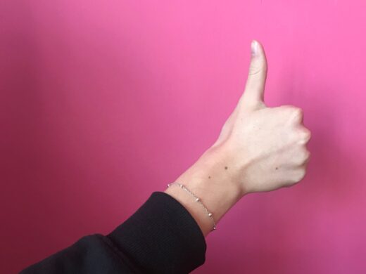 Eine Frauenhand. Der Daumen zeigt nach oben.