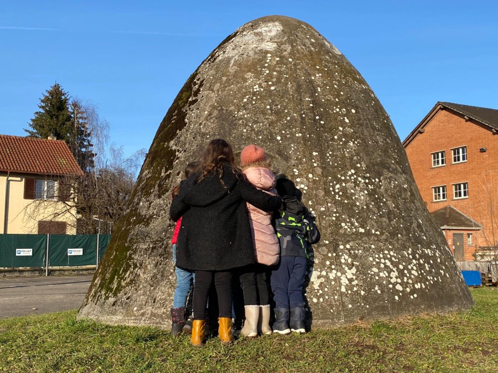 Kinder stehen vor dem "Zeughausbunker" - eine Art Stein.