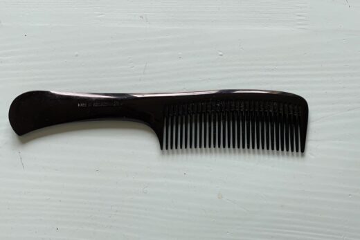 Ein schwarzer Plastikkamm auf einem Tisch