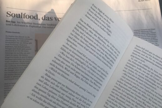 Nahaufnahe von einem Buch, darunter eine Zeitung